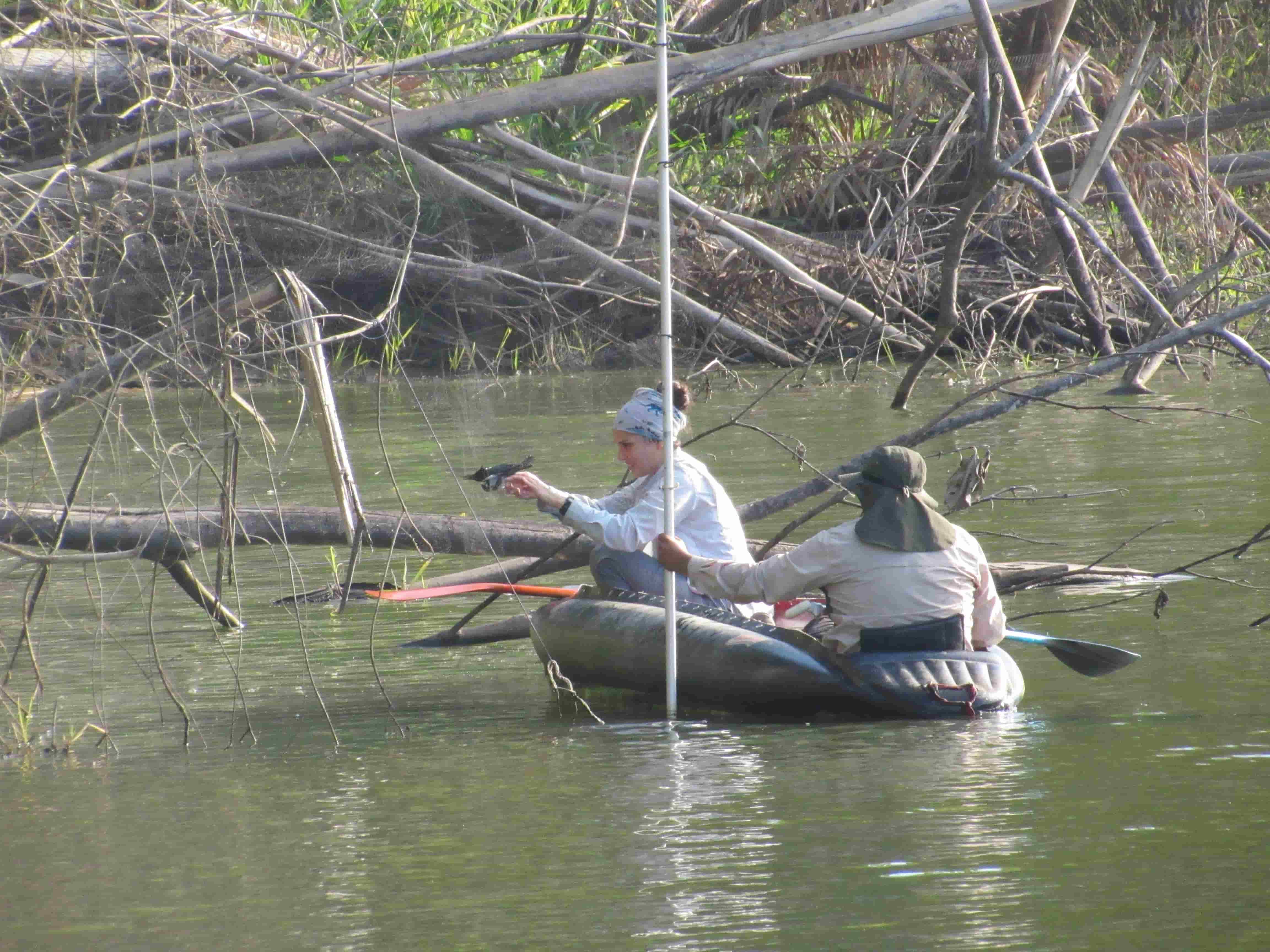 Tali and Victor recovering bird from net in boat